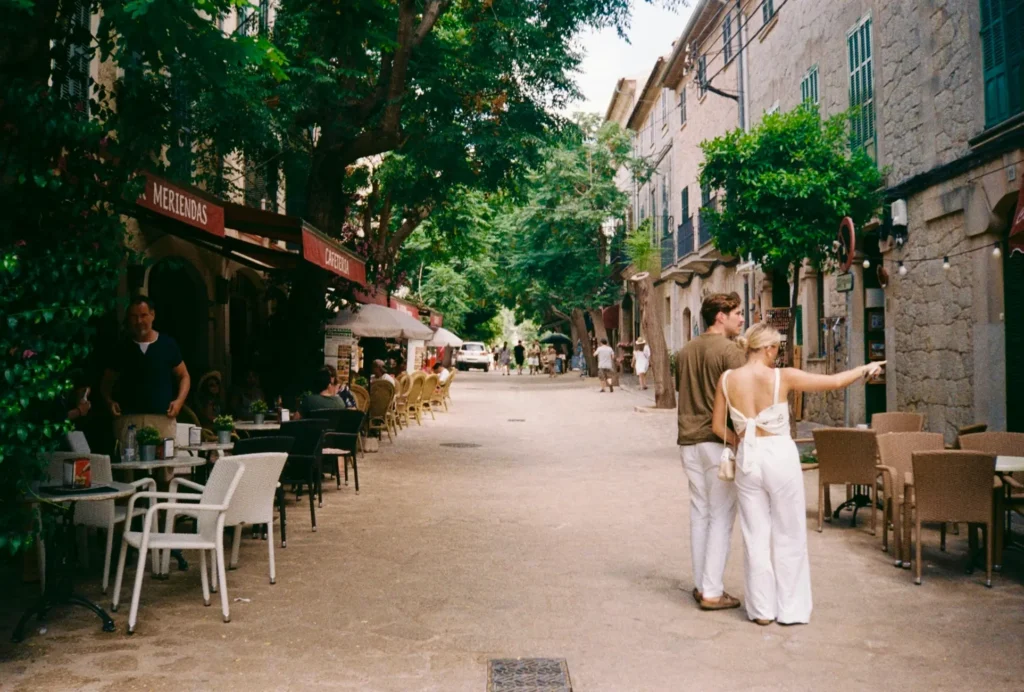 A quiet traditional street in Calvià with an expat couple in view, representing the peace of mind provided by an English insurance broker in Mallorca.