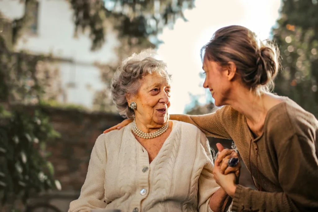 A daughter supporting her elderly mother; highlighting life insurance and family security plans tailored for the expat community in Mallorca.